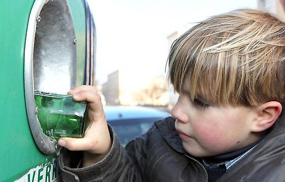Pojke lämnar glas till återvinning